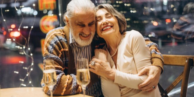 A mature couple laughing together during dinner